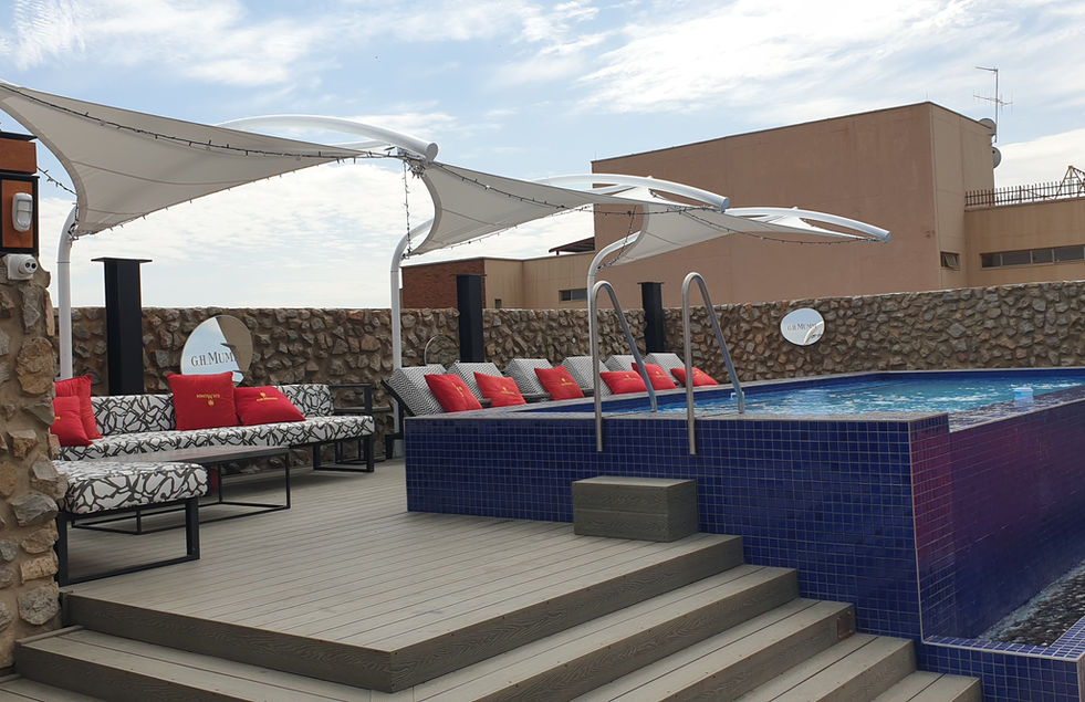 Pool deck with lounge seating under cantilever tensile shades