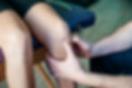Doctor with hands around a patients knees