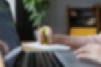 Person squeezing stress ball while at desk working on a laptop
