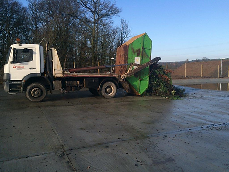 truck emptying skip full of green waste
