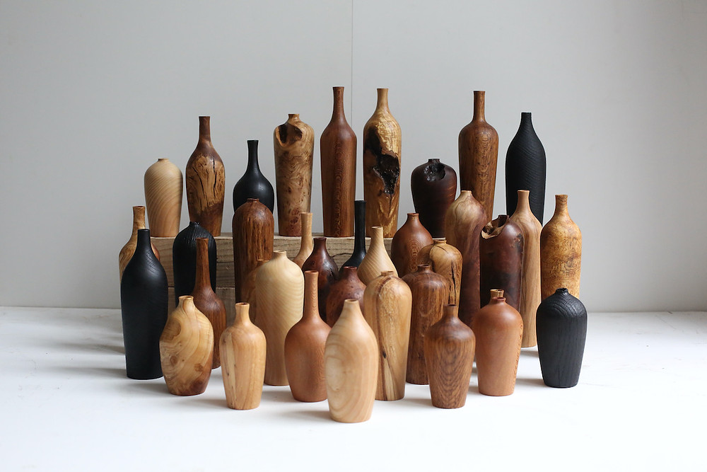 Collection of 37 vases of the same form in various British timbers