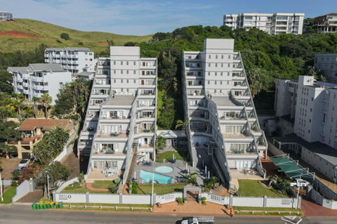 Terraced Umdloti holiday apartments with pool and coastal hillside backdrop