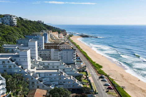 Aerial view of Umdloti oceanfront apartments and beach road along the coast