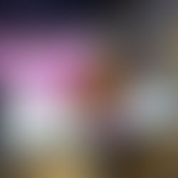 A 2nd Grader using a stylus on an iPad coloring pink ears on a pink axolotl image with his classmates.