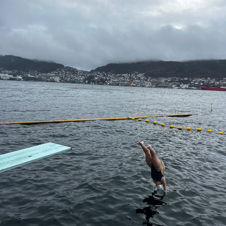 A girl diving into a cold plunge in Bergen, Norway