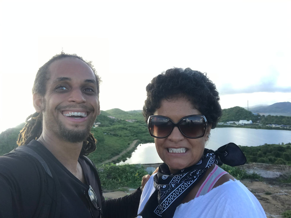 Two people smiling at the top of an Antiguan hill