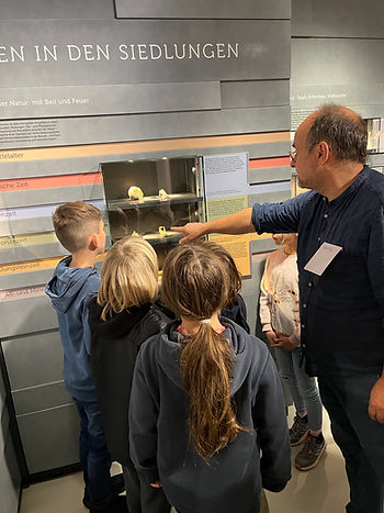 Ein Erwachsener zeigt Kindern ein Museum