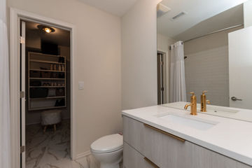 Bathroom vanity with clean cabinetry, mirror, and modern lighting