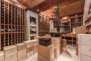 Large wine cellar with built-in wood storage, shelving, and bottle organization