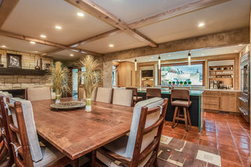 Dining area with wood finishes and open connection to bar and wine storage