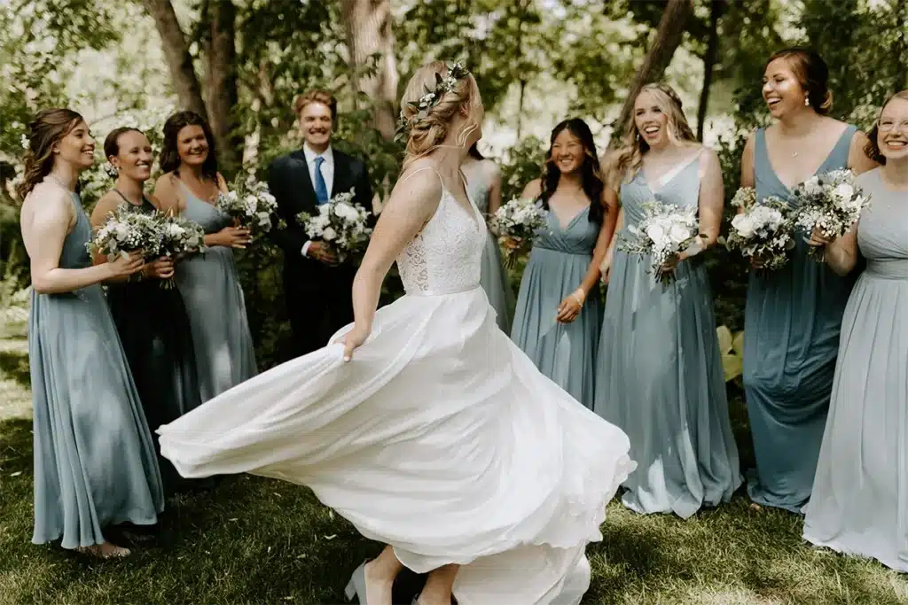 bride spinning in circle with wedding party surrounding her