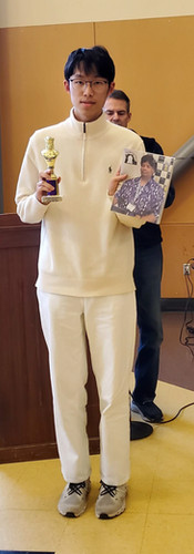 A student holding a trophy and book.