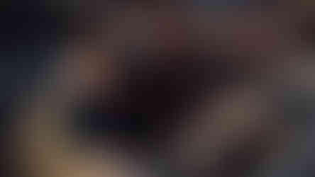 Children are smiling and seated in blue seating in a concert hall.