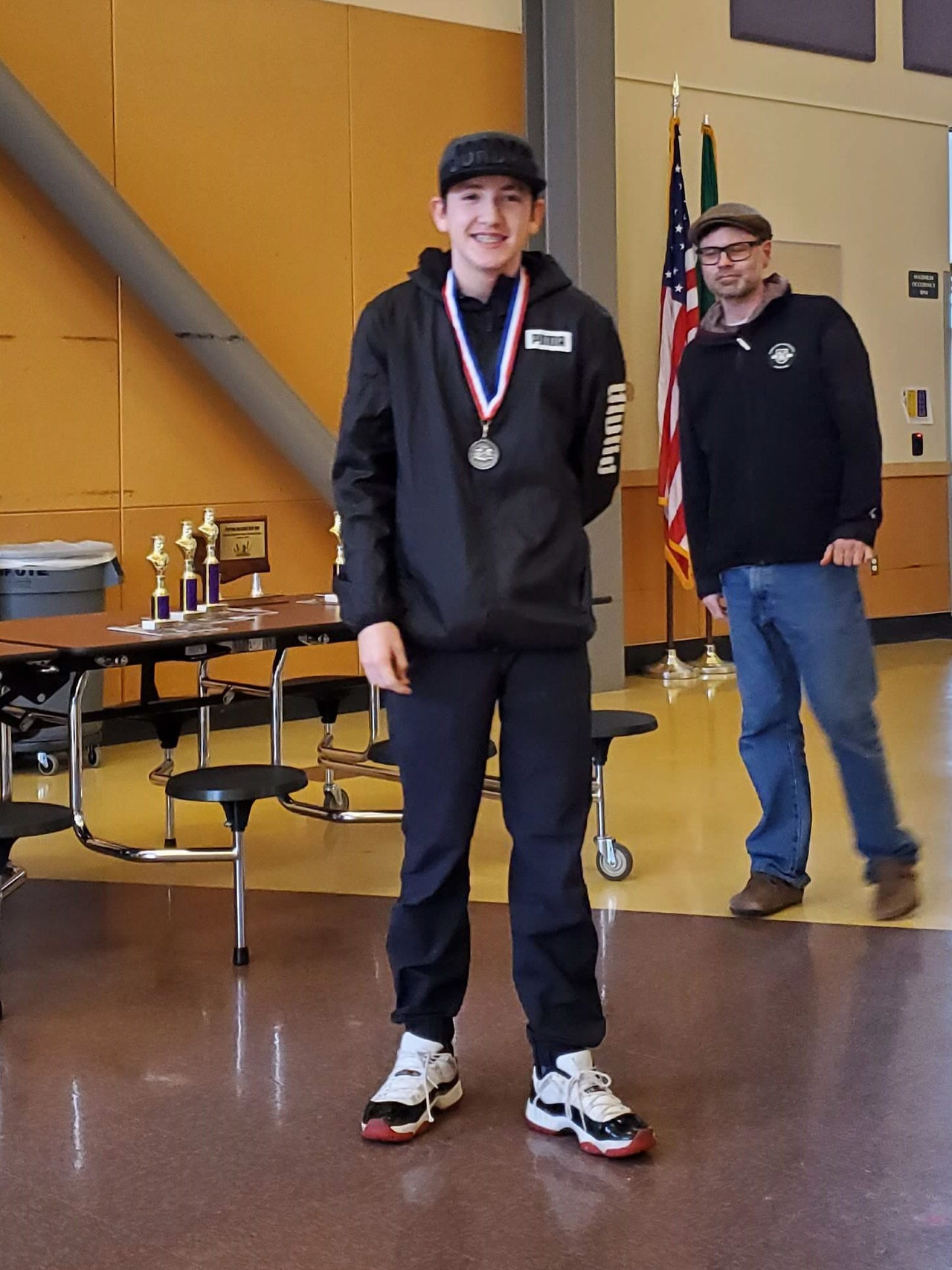 A student smiling and wearing a medal.