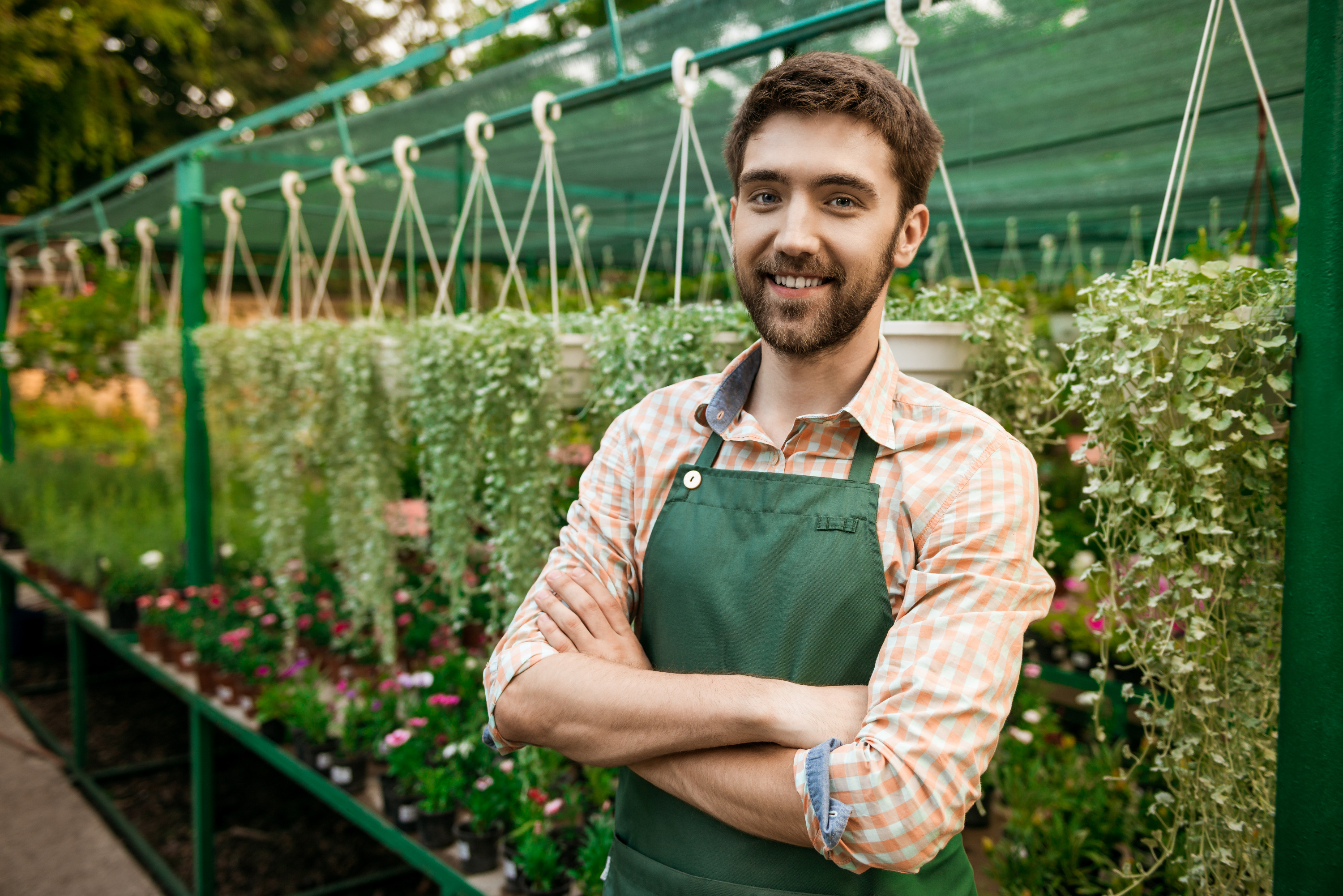 young-handsome-cheerful-gardener-smiling-posing-with-crossed-arms-flowers_edited.jpg