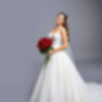a lovely young bride with tears of joy in her eyes holding a bouquet of red roses wearing