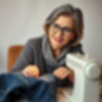a very wise looking middle aged woman looks at us over the top of her reading glasses. Sh