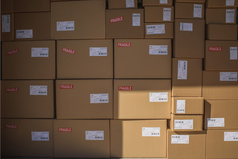 A neatly stacked pile of cardboard courier boxes with shipping labels, ready for dispatch in a warehouse.