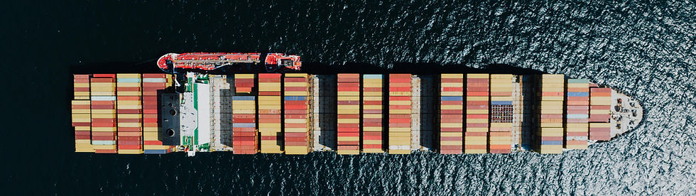 Aerial view of a massive cargo ship navigating through deep blue sea.