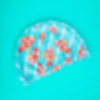 gorro de lycra aguamarina ilustrado con peces naranja fondo turquesa