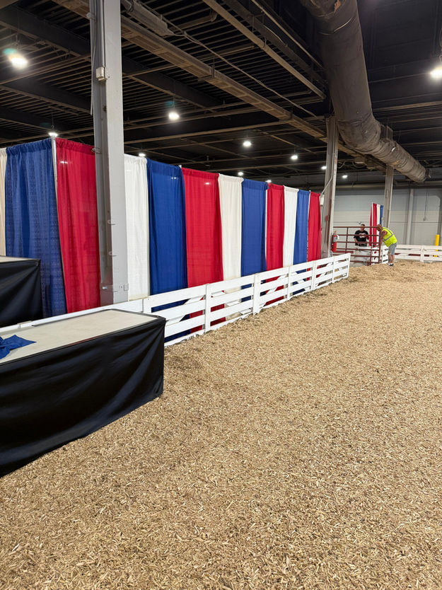 An Indoor Arena Set up with Wood-Chip Flooring and Fencing.