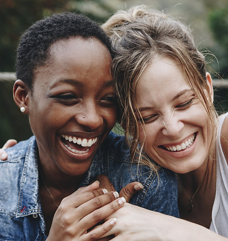 Black woman and white woman laughing after Friendship Therapy