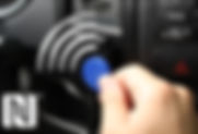 A driver's identification card placed next to a modern key fob used for vehicle access and ignition. The ID card shows the driver's details, while the key fob features buttons for remote control functions.