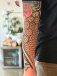 Bold high contrast cohesive geometric sleeve tattoo done tattoo artist by Matisse Maugh of Bloodstone Tattoo Studio in Tacoma, Washington.