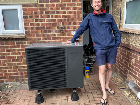 Homeowner standing next to his Samsung R290 heat pump
