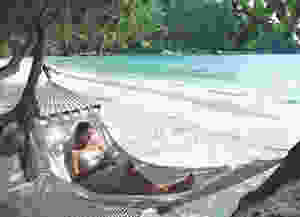 Woman relaxing in hammock at Pangkor Laut Resort, a YTL Hotel.