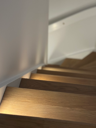 Trätrappa med inbyggda lampor som belyser stegen, modern design