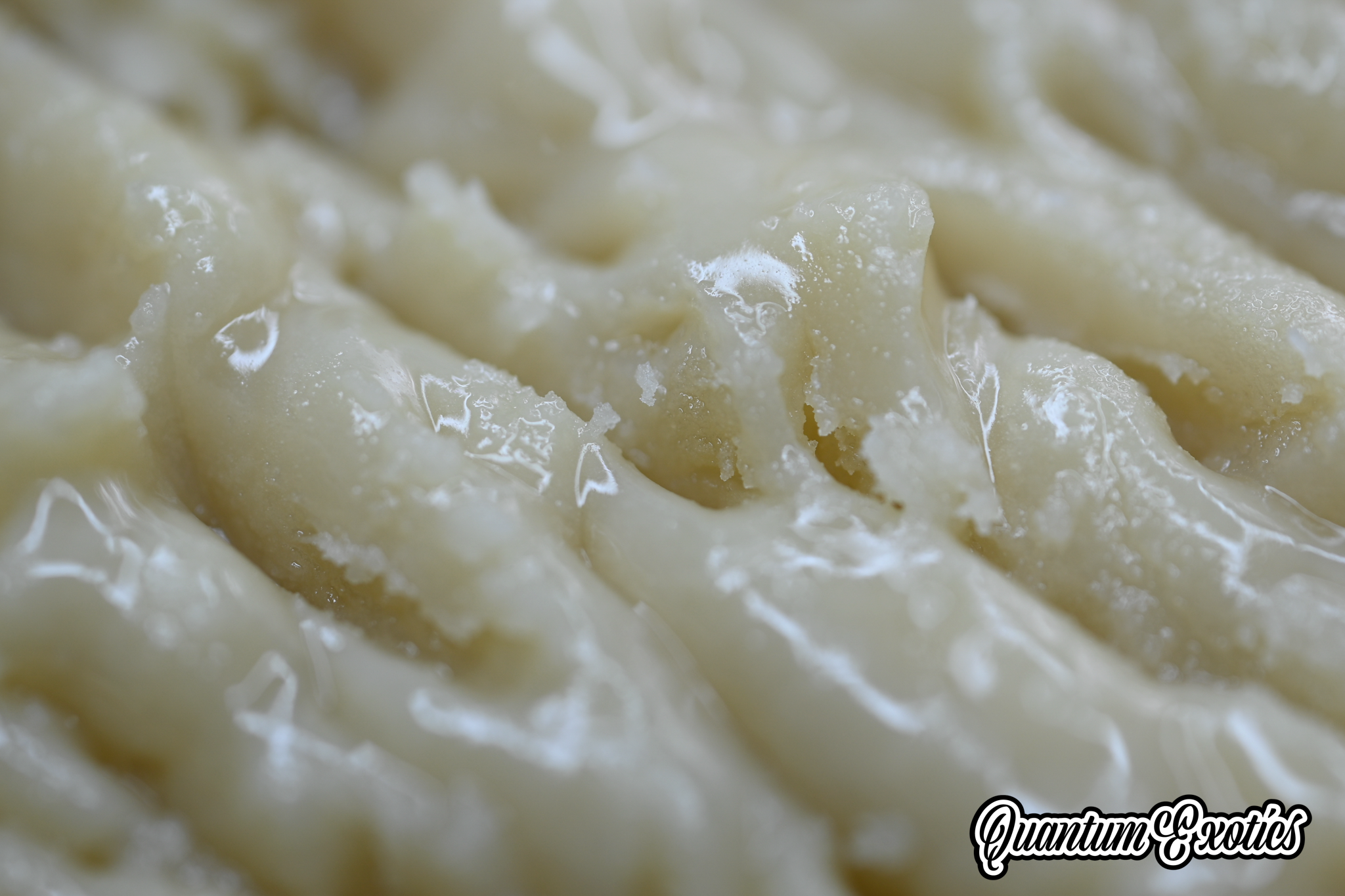 Close-up of a light-colored, waxy substance, possibly Blue Papaya Live Rosin THCa.