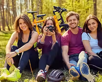 groupe-people-relaxing-after-bicycle-ride-forest-female-taking-picture-with-digital-compac