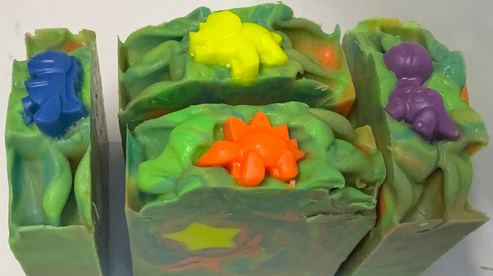 Green, Blue, and Orange swirled soap with yellow star embed topped with a dinosaur embed