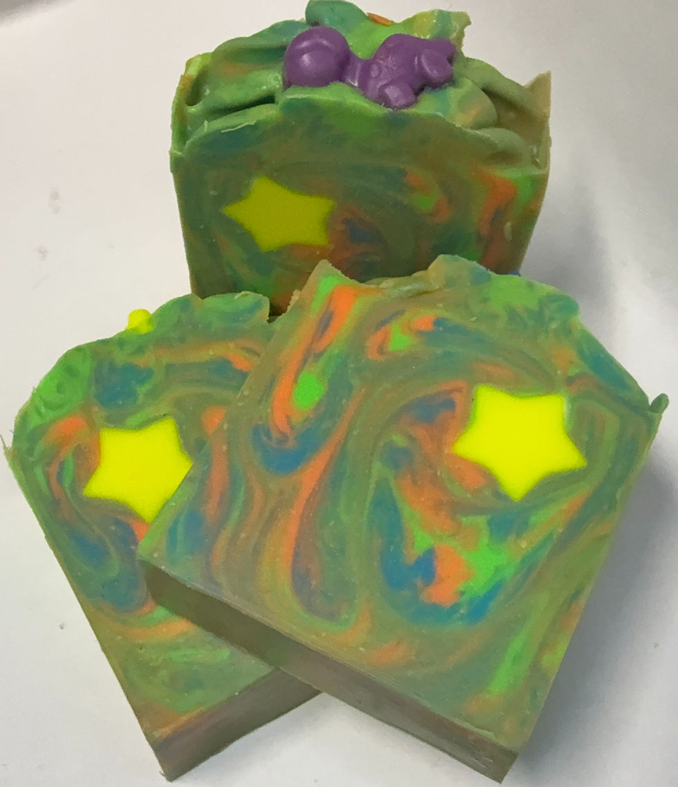 Green, Blue, and Orange swirled soap with yellow star embed topped with a dinosaur embed