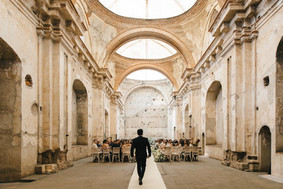 A groom entering his wedding ceremony in Santa Clara Convent, a historical wedding venue in Antigua Guatemala, with its spectacular colonial architecture it is the perfect setting for luxury weddings. Photo by Mariel Orellana, international fine art and luxury wedding photographer and video.