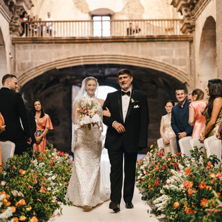 A bride and groom at a luxury wedding at the Capuchin Ruins in Antigua Guatemala, surrounded by guests and floral arrangements. Photo of luxury wedding venues in Guatemala