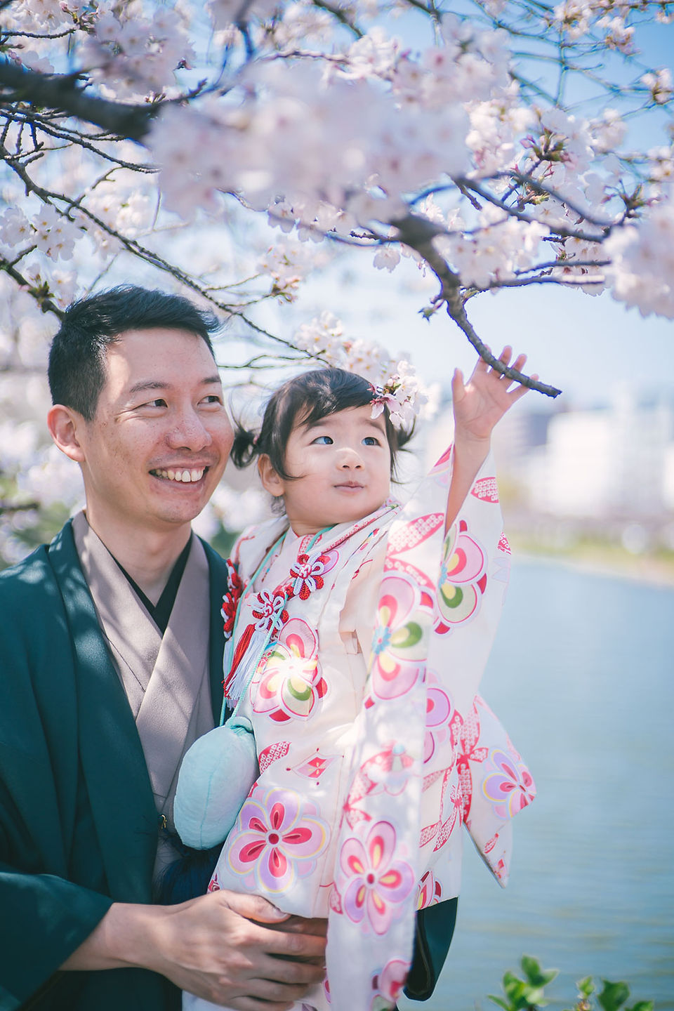 福岡大濠公園親子寫真，家庭成員在櫻花和自然光下的溫馨互動紀錄