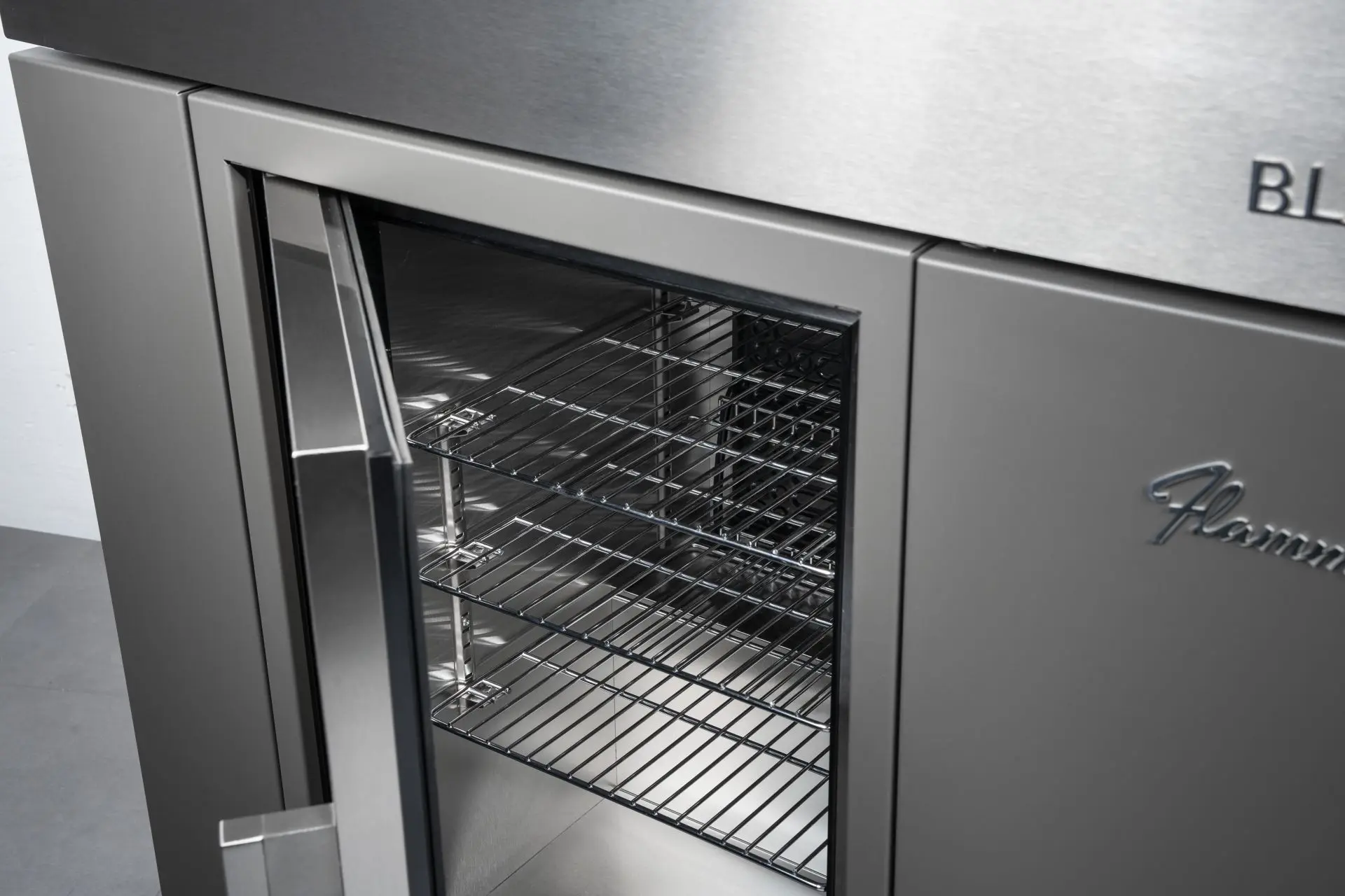 Zoom sur le réfrigérateur du module bar Flammkraft Block B avec porte vitrée et clayettes métalliques, conçu pour une conservation optimale.