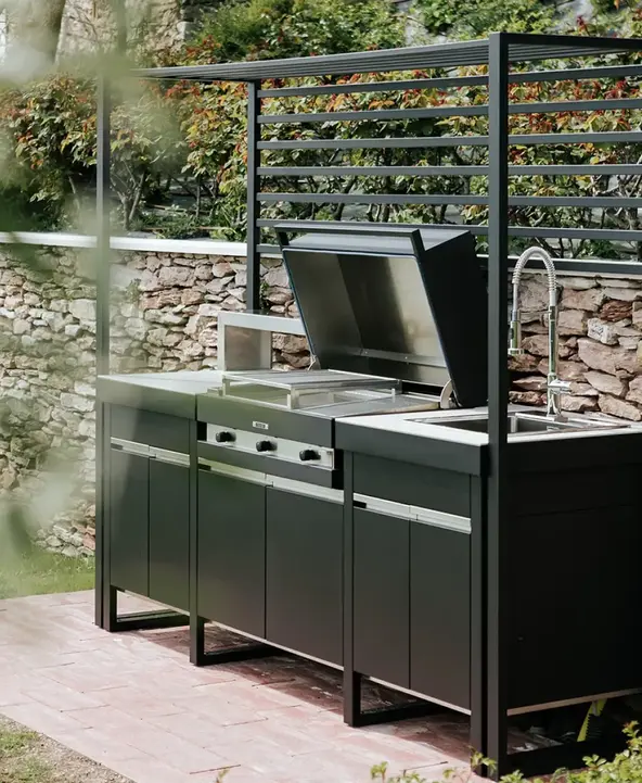 Cuisine extérieure modulable en acier noir avec plancha, évier et rangements, conçue pour une installation rapide et adaptable à tout espace extérieur.