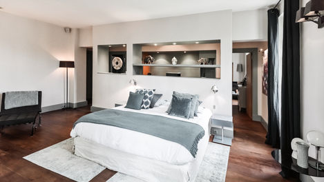 Spacious Levant bedroom with modern decor, a double bed with blue-themed bedding, and built-in shelves displaying decorative items