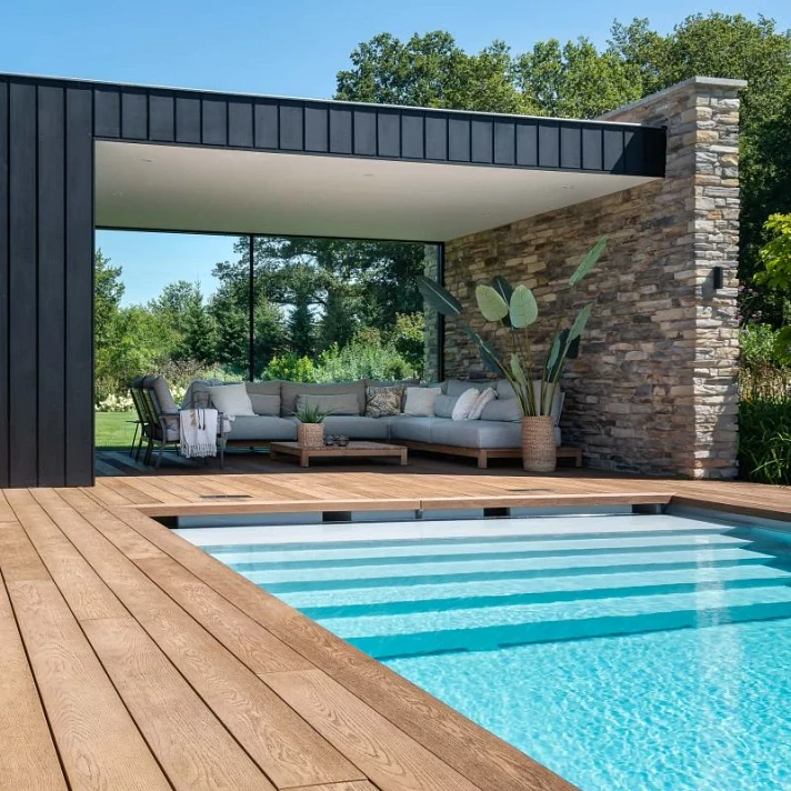 Terrasse Millboard Coppered Oak entourant une piscine moderne avec pool house contemporain