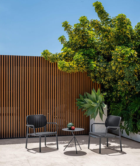 Fauteuil MEG Talenti graphite en situation extérieure sur terrasse ensoleillée