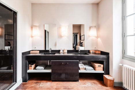 Luxurious bathroom in the Levant suite with a double sink vanity made of Zimbabwe granite, modern fixtures, and stylish lighting