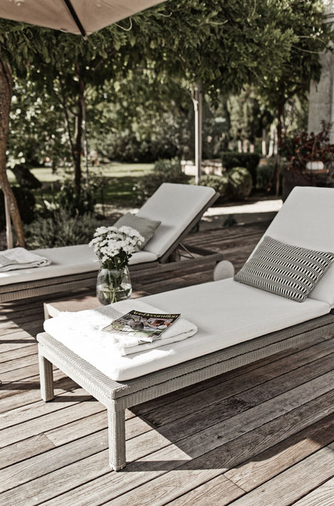 The spacious wooden deck at Mas de Campe adjacent to the 15x4 meter heated and salted pool. Comfortable sun loungers and shaded areas provide an ideal spot for relaxation and enjoyment of the beautiful garden views