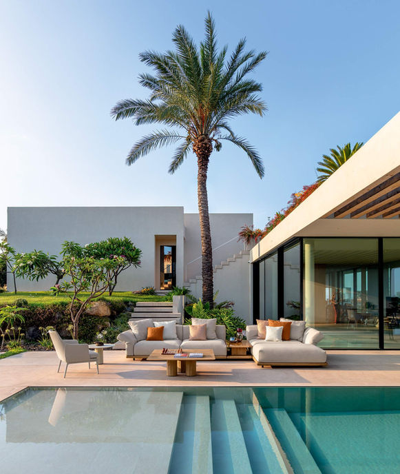 Fauteuil Claude assorti au canapé Elton sur une terrasse bord de piscine, décor contemporain