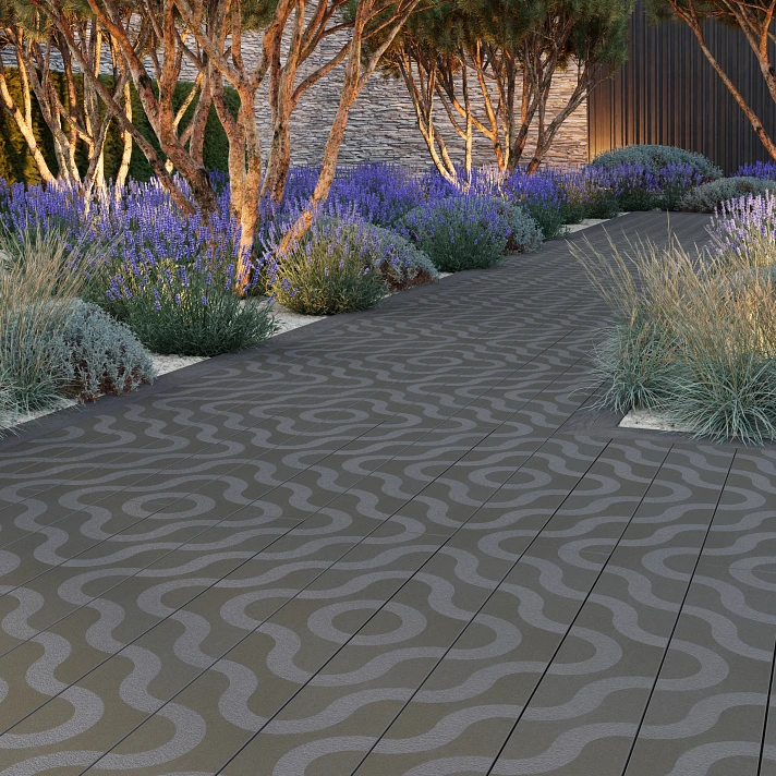 Allée de jardin bordée de lavandes et d'arbres, pavée avec lames Millboard à motifs contemporains gris.