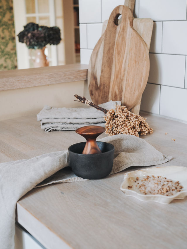 Mortier Kiruna en fonte noire sur un linge beige, dans une cuisine au style naturel.