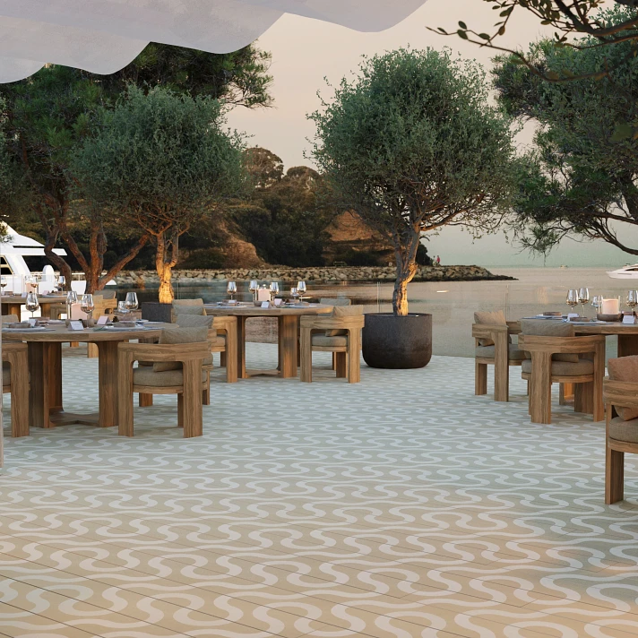 Restaurant en bord de mer avec sol Millboard à motifs ondulés, ambiance coucher de soleil.
