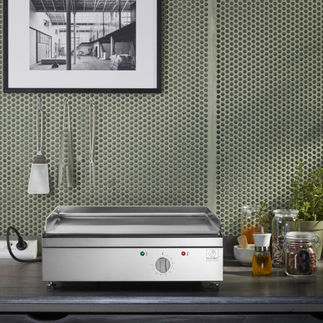 Plancha Planet Outdoor en inox brossé sur comptoir, commande frontale et rebord anti-projections.
